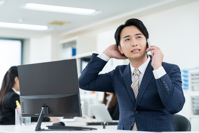 電話をかけようとして緊張するビジネスマンの様子