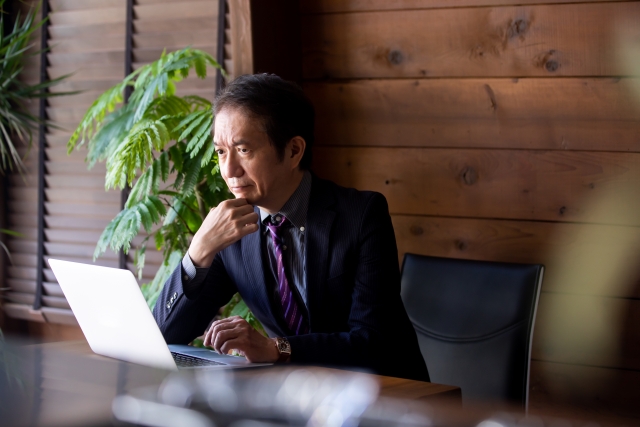 営業が苦手で悩む一人社長がデスクで考え込んでいる様子