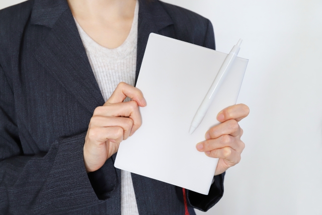 ヒアリングシートをテーブルに広げてビジネスパーソンがペンで記入している場面、会議室かカフェテーブル、集中した表情