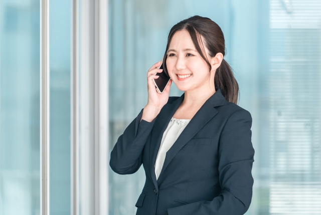 一人社長が笑顔で電話をしている