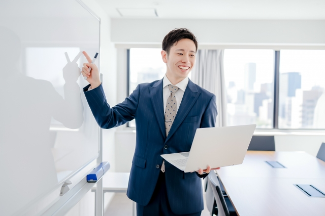ホワイトボードの前でフローを説明するビジネスパーソン