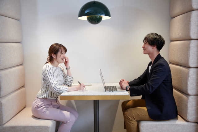 笑顔でビジネス会話をする男女