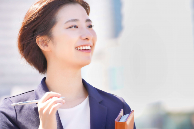 ノートにメモを書きながら商談の振り返りをしているビジネスパーソン