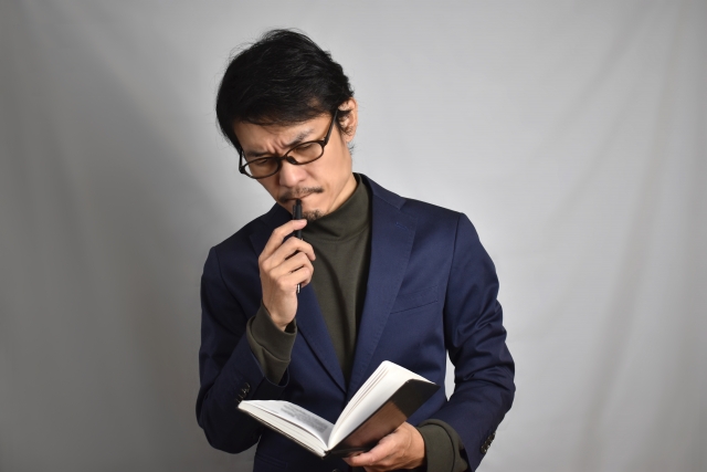 一人社長がデスクでメモを取りながら学んでいる場面