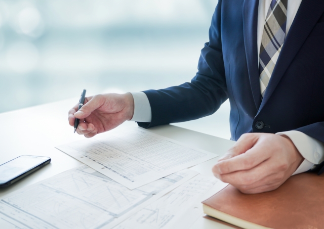 一人社長が顧客と向き合い、メモをとりながら話を聞いている商談シーン