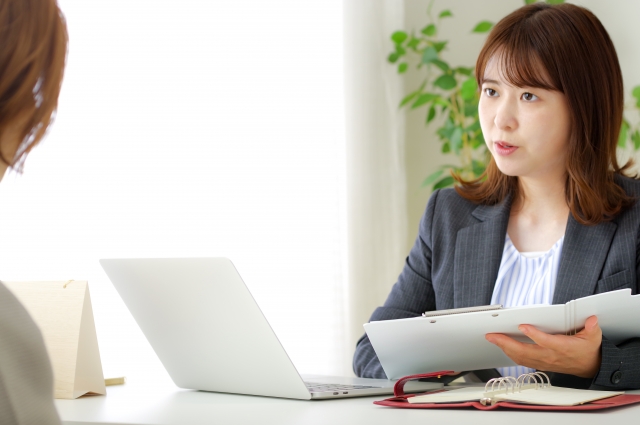 商談テーブルで向かい合う営業と顧客